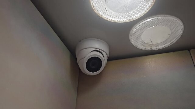 Camera and lights installed in a corner of an elevator are observed with no apparent movement or change