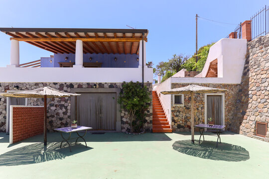 Stone villa courtyard with parasols and green floor
