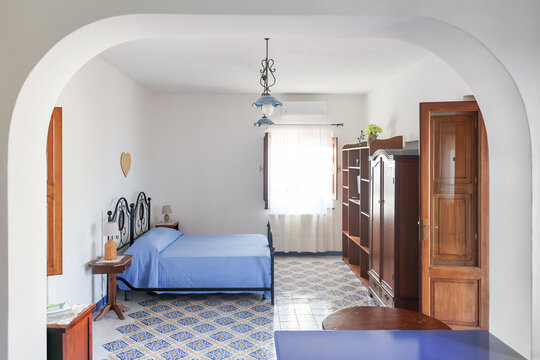 Arched doorway frames a blue quilted bedroom