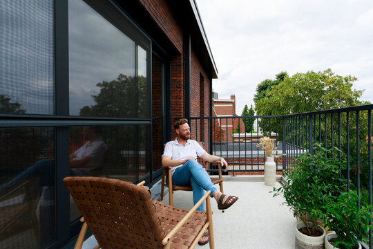 Man Sitting on a Balcony Enjoying the Fresh Air