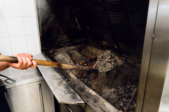 Cook Tending a Wood-Fired Grill