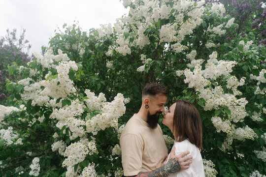 Romantic couple sharing intimate moment among lilacs