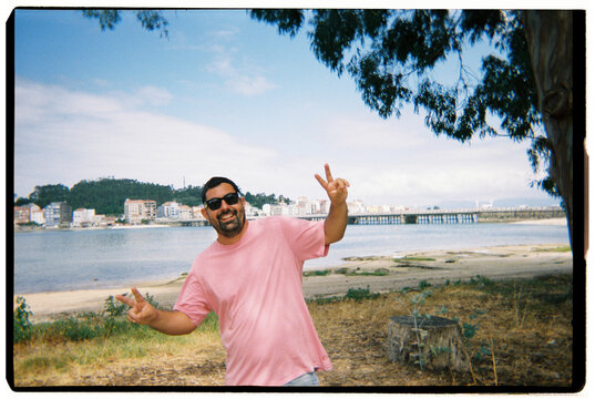 Man smiling and making peace signs on vacation