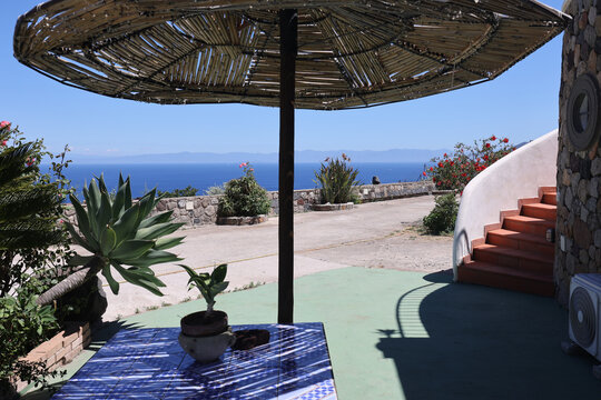 Bamboo parasol over tiled table with ocean horizon