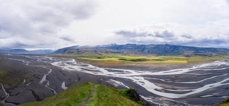 Panoramic high angle view of intricate braided rivers and glacial outwash plains viewed from the summit of Stora Dimon mountain in Iceland.