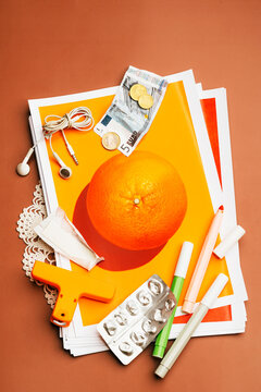 Scattered daily objects on printed photograph of an orange