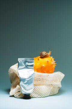 Used metal cream tube in front of Kiwano in a fabric mesh bag
