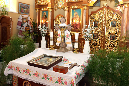 A decorated church altar with a cross, candles, icons, and flowers prepared for a Christian religious ceremony.