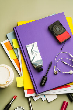 Messy collection of stationery and daily objects on purple notebook