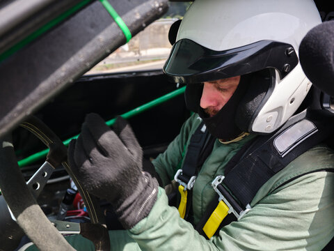 Rally driver preparing for race in cockpit