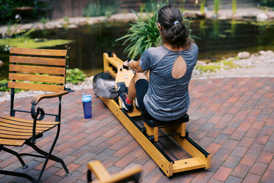 middle aged women working out outdoors with rowing fitness machine