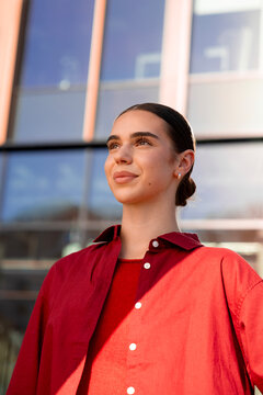 Confident woman looking ahead modern office building on a city street