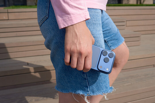 Person holds a smartphone while standing on wooden steps