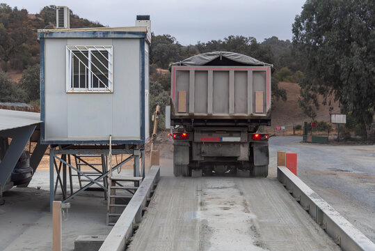 Dump truck carrying hot asphalt driving off a scale at a production plant