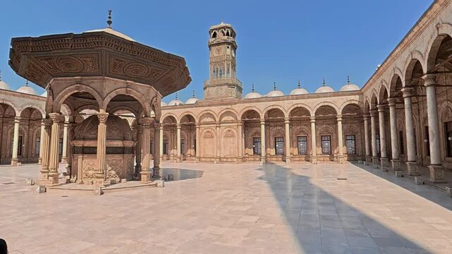 El patio con la fuente de abluciones y la torre del Reloj de la mezquita de alabastro del Cairo, Egipto	