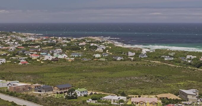 Betty's Bay South Africa Aerial v3 zoomed flyover coastal residential area, featuring mountains, ocean views, and winding roads through lush vegetation - Shot with 5k Camera - Jan 9th 2024