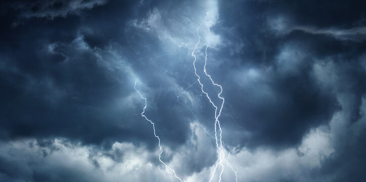 Thunderous dark sky with black clouds and flashing lightning. Panoramic view. Concept on the theme of weather, natural disasters, storms, typhoons, tornadoes, thunderstorms, lightning, lightning.