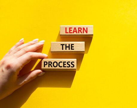 Learn the process symbol. Concept words learn the process on wooden blocks arranged as steps. Businessman hand arranging wooden blocks. Learning and development concept. Yellow background. Copy space.