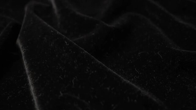Luxurious black velvet fabric texture with soft folds and draping