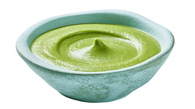 Smooth green avocado puree in a textured light blue ceramic bowl, isolated on transparent background