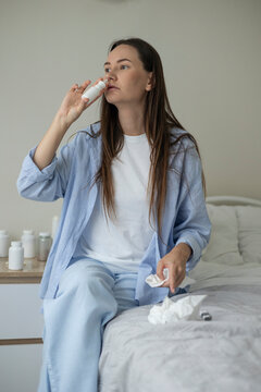 Sick woman resting in bed with symptoms of fever, runny nose and cough during an illness