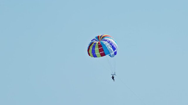 man parasailing over the sea in barcelona