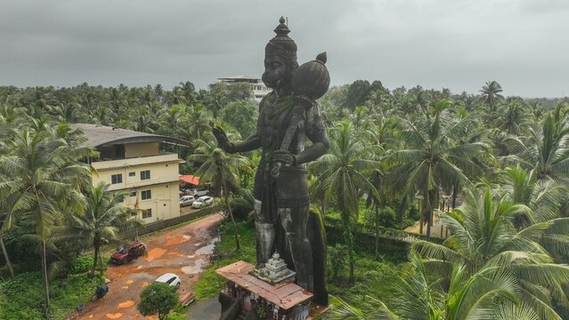 Aerial view of the massive Hanuman statue surrounded by lush palm trees and greenery in Udupi, Karnataka, India.