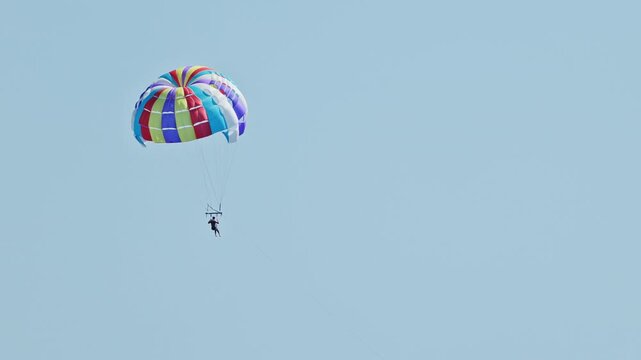 man parasailing over the sea in barcelona