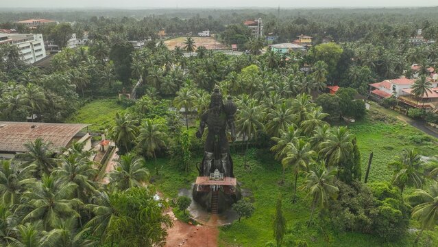 Aerial view of the large Shiva statue surrounded by lush palm trees and greenery in Udupi, Karnataka, India.