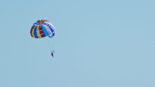man parasailing over the sea in barcelona