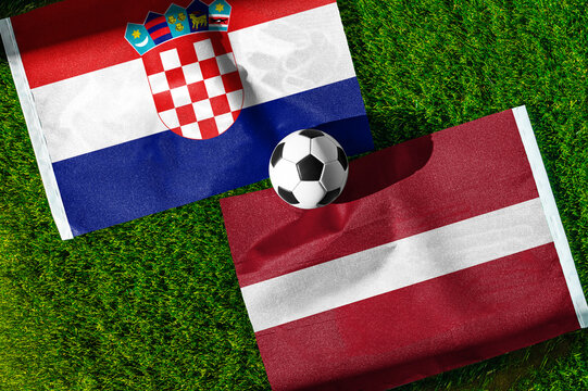 Croatia vs. Latvia football match. National flags on green grass with soccer ball in the middle. Football background for international match.