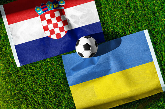 Croatia vs. Ukraine football match. National flags on green grass with soccer ball in the middle. Football background for international match.