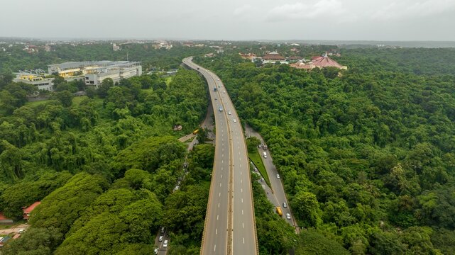 Aerial view of the Atal Setu bridge surrounded by dense tropical forest and lush greenery in Panaji, Goa, India.
