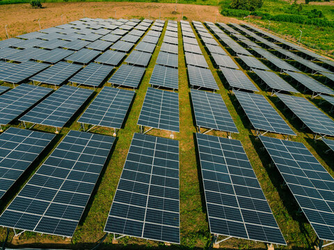 Aerial view of a large solar farm with rows of photovoltaic panels installed on a grassy field in Ogun State, Nigeria.