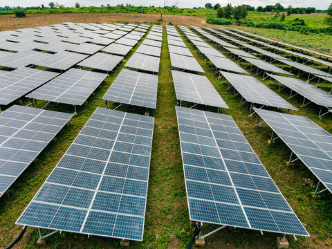 Aerial view of a large solar farm with rows of photovoltaic panels installed on a grassy field in Ogun State, Nigeria.