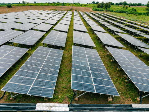 Aerial view of a large solar farm with rows of photovoltaic panels installed in a grassy field in Ogun State, Nigeria.
