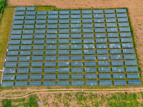 Aerial view of a large solar farm with rows of photovoltaic panels installed in a rural landscape in Ogun State, Nigeria.