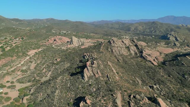 Vasquez Rocks, north of Los Angeles, California, are shown in an aerial flyby view during the day. This unique formation is composed of sedimentary rock and is the result of tectonic uplift.