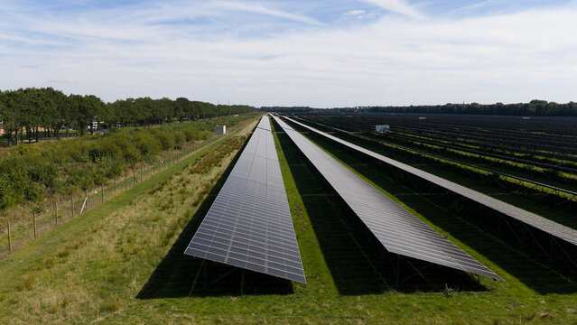 Aerial view of Zonnepark Pekela featuring long rows of solar panels installed in a green field in Oude Pekela, Groningen, Netherlands.