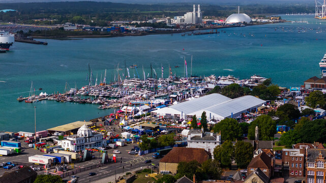 Aerial view of the Southampton International Boat Show featuring yachts docked in the marina and large white exhibition marquees along the waterfront in Southampton, England, United Kingdom.