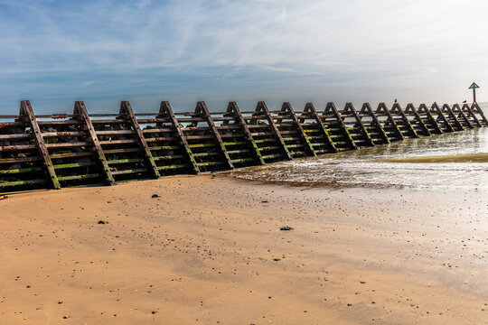 Wooden and concrete groynes are used along the beach at Walton-on-the-Naze as a form of hard coastal engineering to stop longshore drift and reduce beach erosion. Shot 21 September 2026.