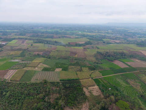 Aerial view of agricultural fields and plantations in the rural landscape near Lahor Dam in Kecamatan Sumberpucung, Jawa Timur, Indonesia.