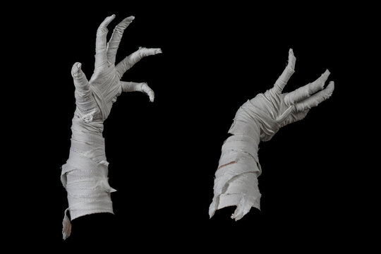 Mummy's hands wrapped in a bandage creepily moving on isolated background. The hand of the mummy monster for Halloween horror concept