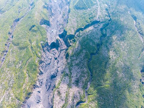 Aerial view of the volcanic landscape of Mount Semeru showing deep erosion channels and rocky terrain left by catastrophic eruptions near Pronojiwo, East Java, Indonesia.