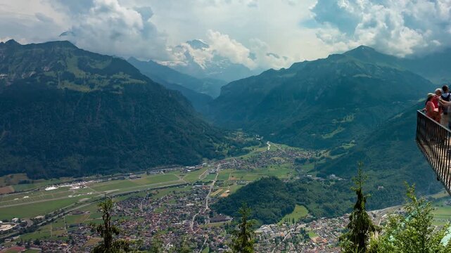 Interlaken Switzerland timelapse of clouds moving over Bernese Alps valley from Harder Kulm viewing platform with passing tourists