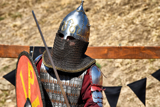 Medieval warrior with helmet, chainmail armor, and shield in combat pose