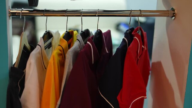 Colorful Polo Shirts Hanging on Metal Rack, Row of Multicolored T-Shirts on Clothing Rail