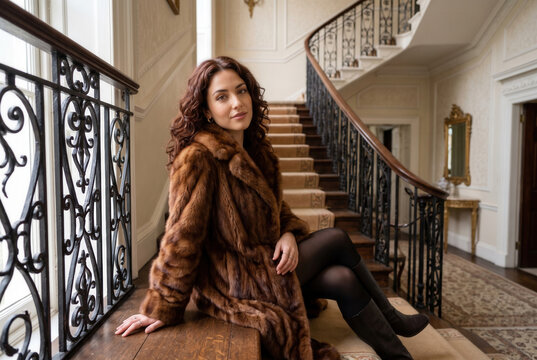 Woman in a Brown Fur Coat Seated on an Ornate Staircase