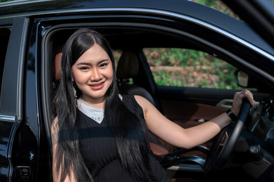 Young Asian woman stepping out from the car