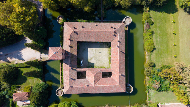 Peschiera Borromeo, Italy - 19 September 2026: Aerial view of Castello di Peschiera Borromeo, a historic moated castle with a square courtyard and red-tiled roofs.